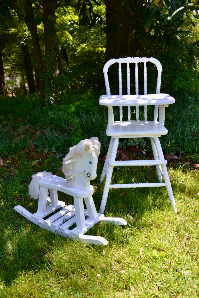 White vintage high chair and white rocking horse styled as event rental pieces