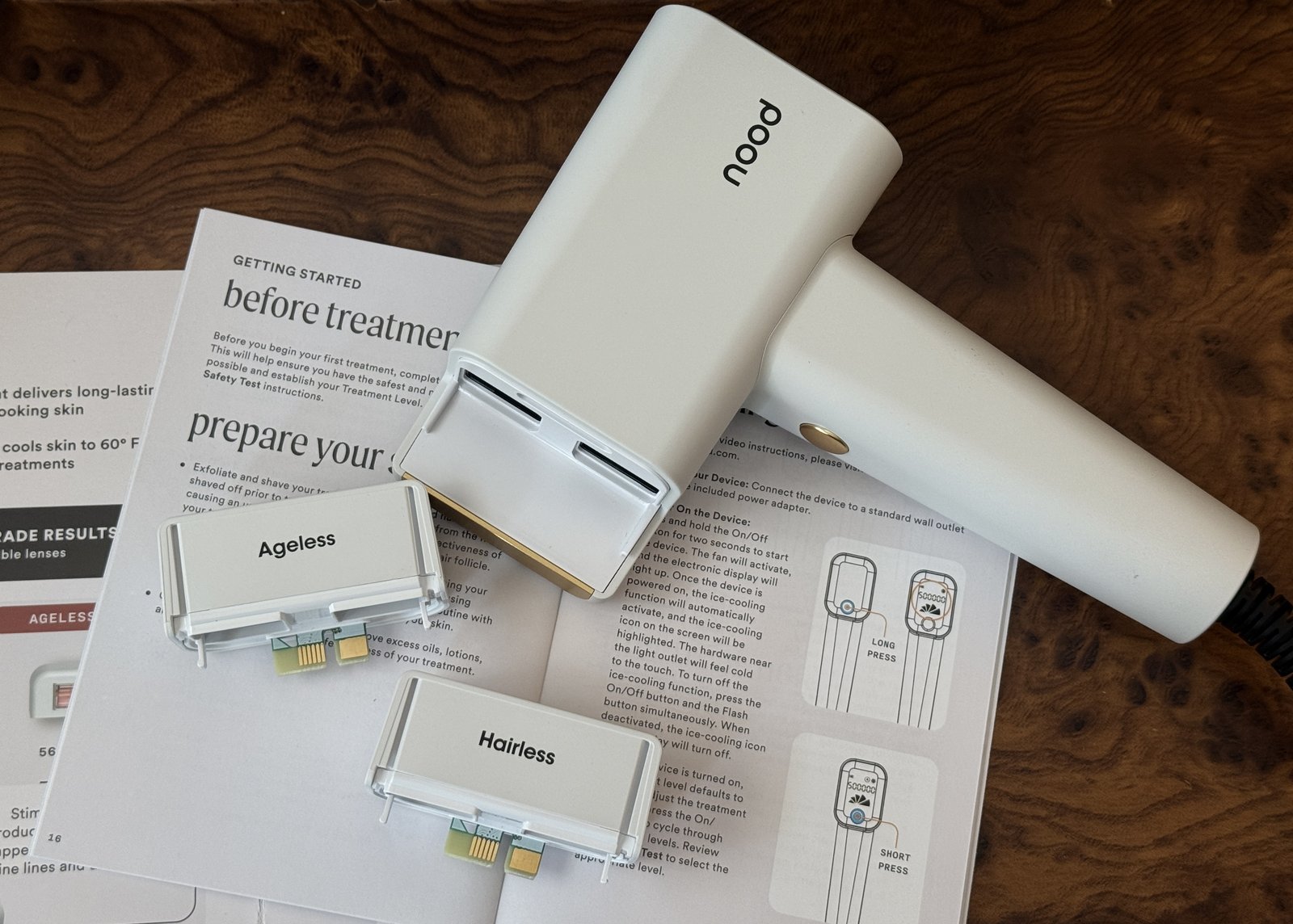 The Nood Flasher Pro handset resting on its prepare your skin instruction card with both lens cartridges